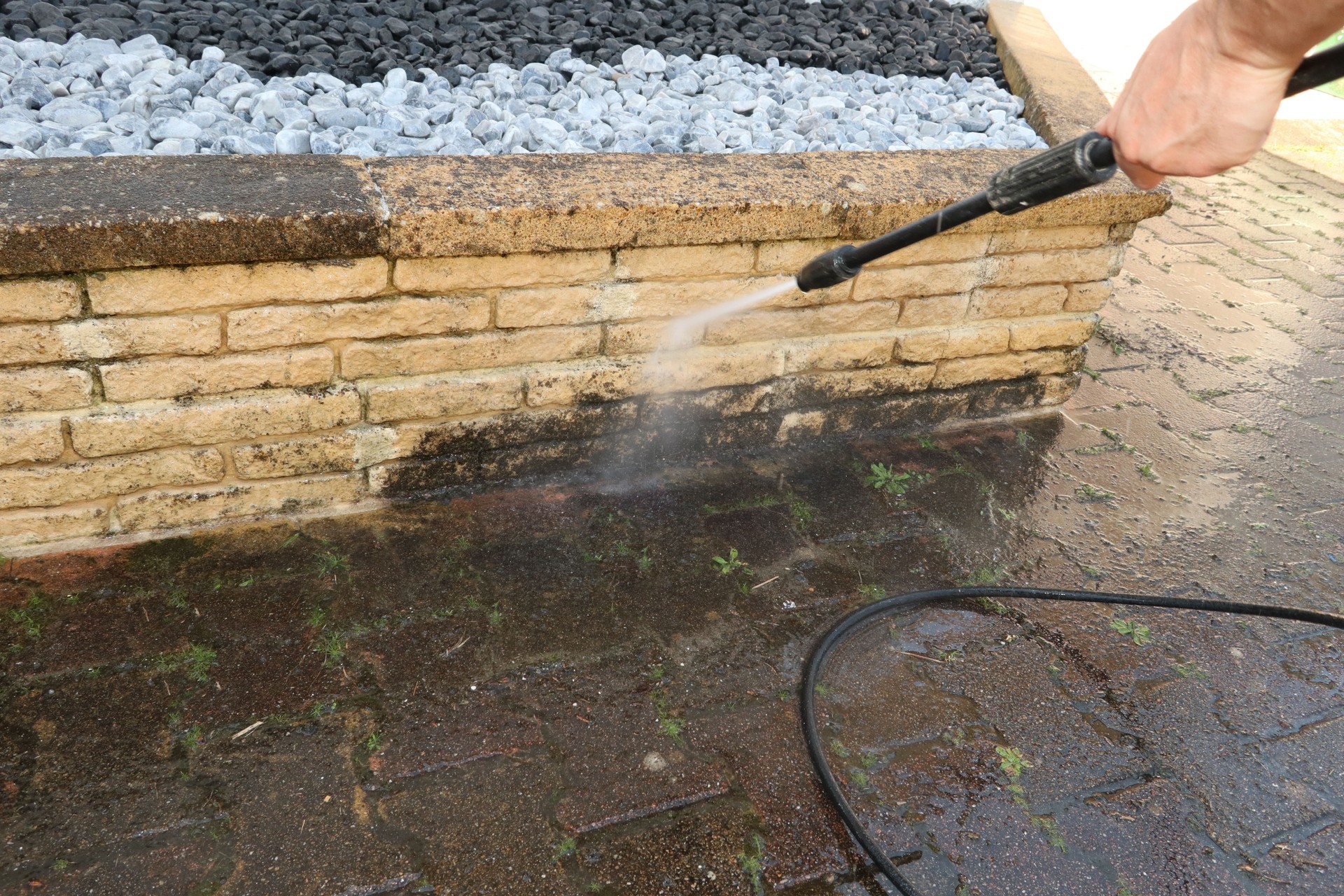 Man cleaning dirty walkway with high pressure water cleaner professional cleaning services concept